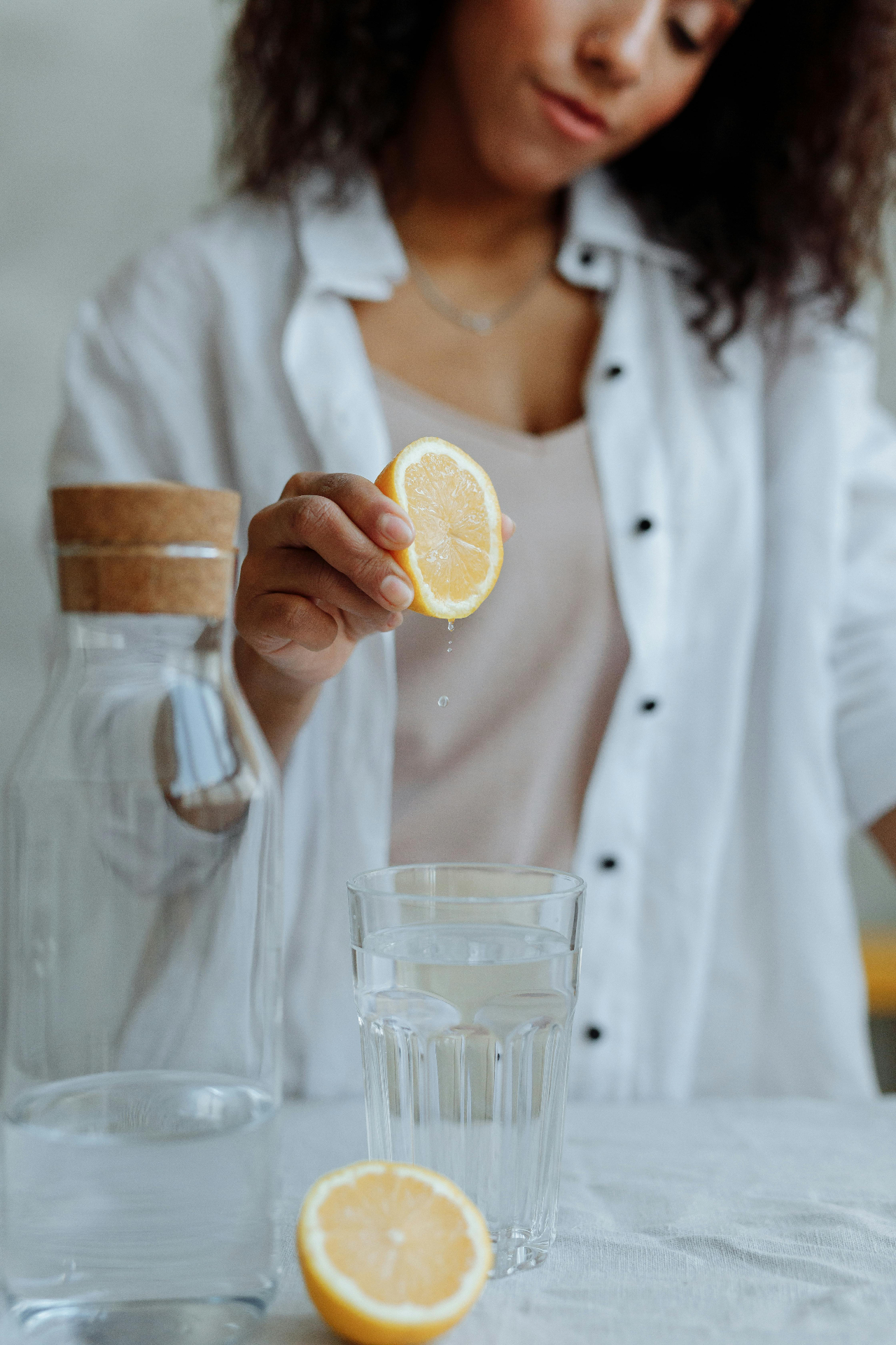 Woman pouring lemon water — a calm daily ritual